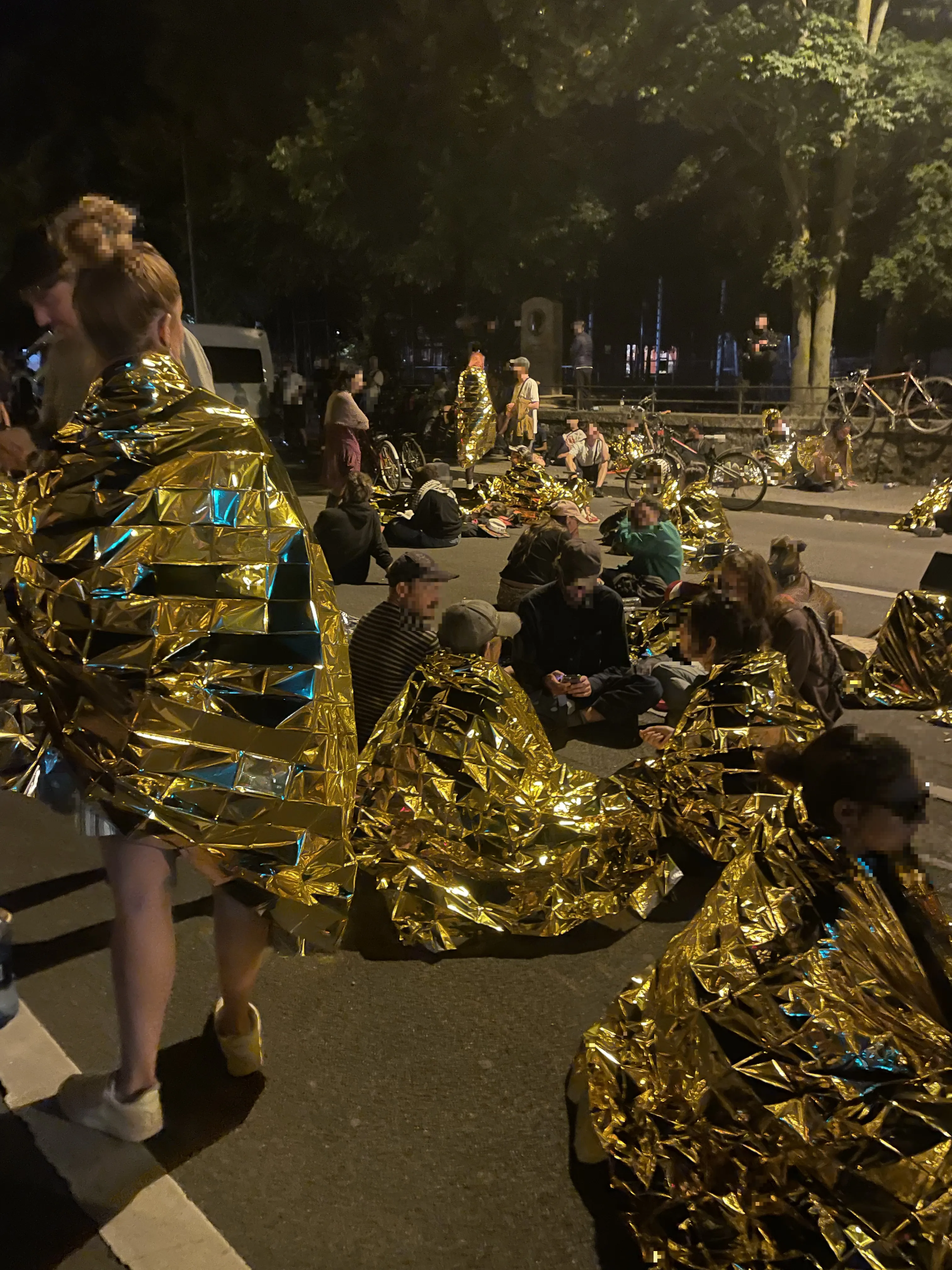 Des personnes enveloppées dans des couvertures de survie.
